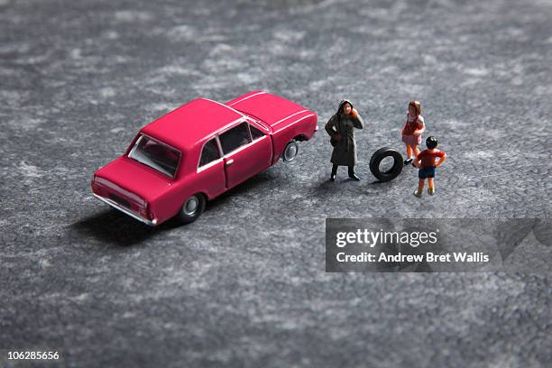 model family near a toy car with a punctured tyre - toy car accident stock pictures, royalty-free photos & images