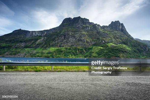 road along a fjord in norway, mountain on background, side view - country road side stock pictures, royalty-free photos & images
