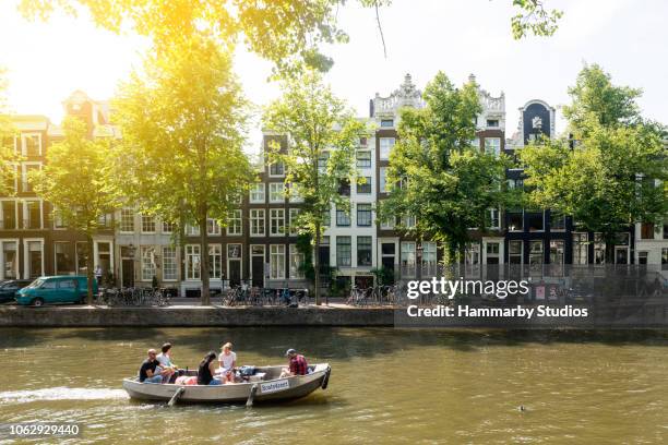 kleine groep van vrienden reizen door een boot op de rivier van de amstel in amsterdam, nederland - amsterdam mensen boot stockfoto's en -beelden