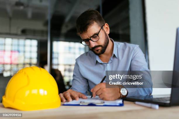 architect doing some work at office - man drawing stock pictures, royalty-free photos & images