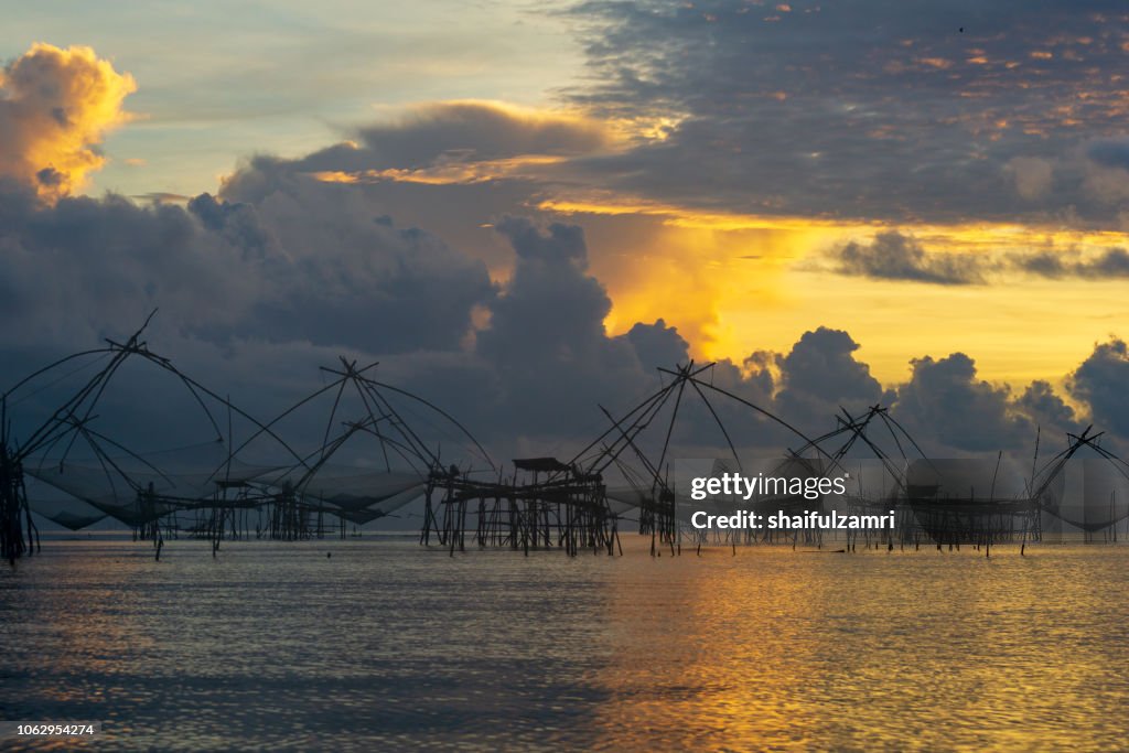 Traditional fishing nets made from bamboo and wood over sunrise at Phatthalung, Thailand.