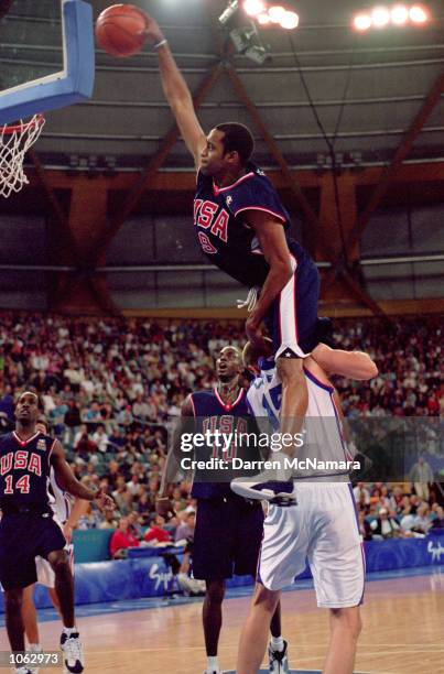 Vince Carter of the USA leaps over Frederic Weis of France to dunk during the Mens Basketball Preliminaries at the Dome in the Olympic Park on Day 10...