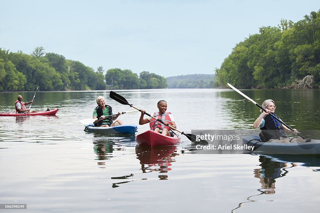 Couples kayaking on river