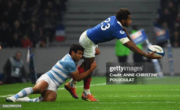 France's back row Benjamin Fall passes the ball as he is tackled by Argentina's centre Matias Orlando during the international rugby union test match...