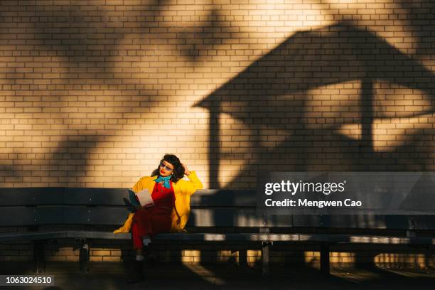 young woman reading at sunset - i love new york fotografías e imágenes de stock