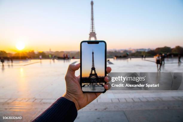 tourist taking picture of eiffel tower with smart phone, personal perspective view, paris, france - tour france stock pictures, royalty-free photos & images