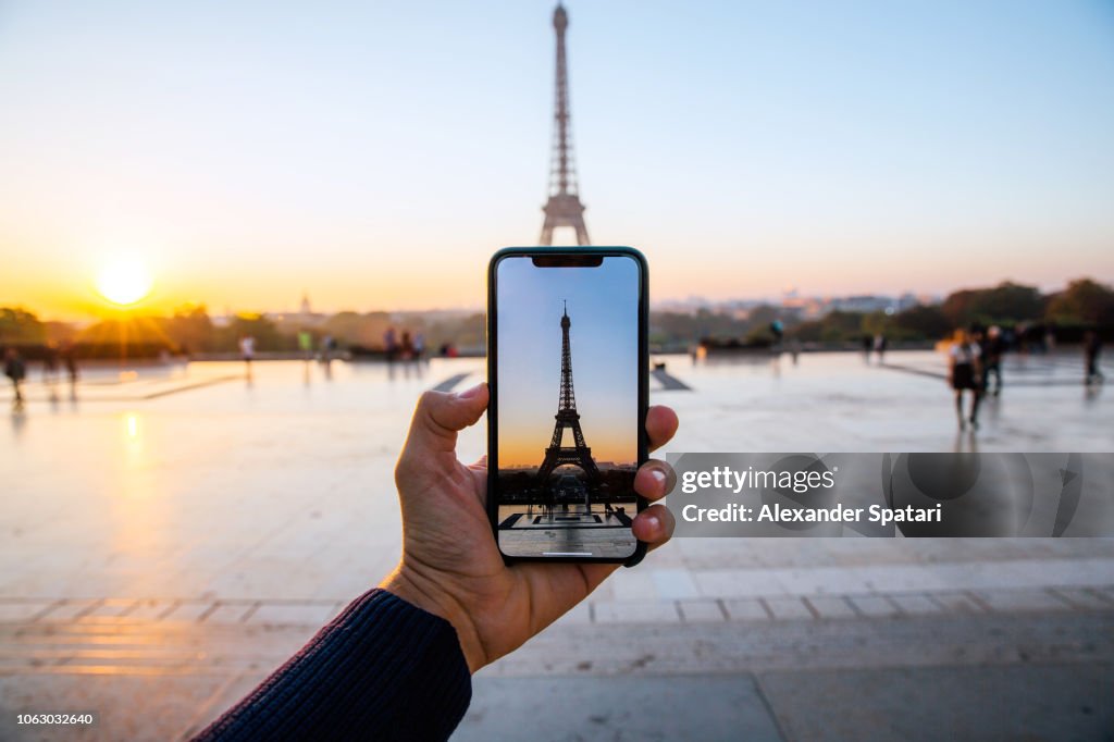 Tourist taking picture of Eiffel Tower with smart phone, personal perspective view, Paris, France