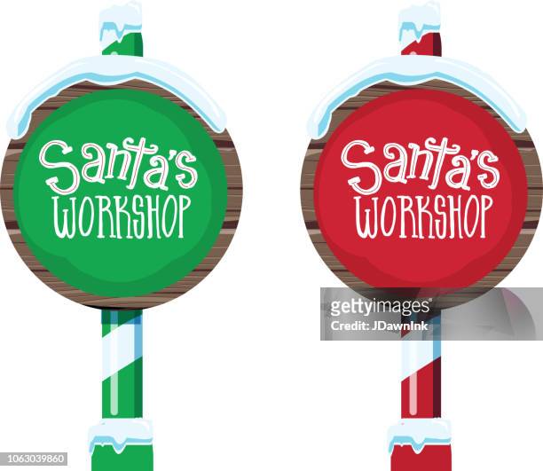 wooden winter christmas santa workshop and elf workshop sign with handwriting or hand lettered text - santas workshop stock illustrations