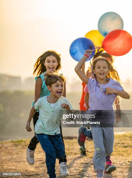 gruppe der kinder mit luftballons - kids party balloons stock-fotos und bilder