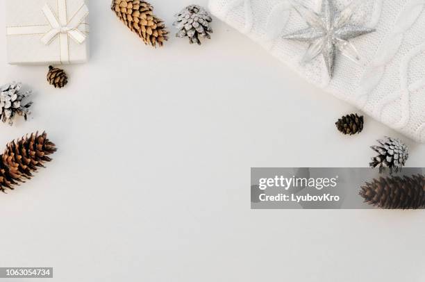 cozy white christmas composition. knitted winter mittens, socks, sweater next to the cones, new year decor and gifts. flatley. top view. - flatlay stock-fotos und bilder