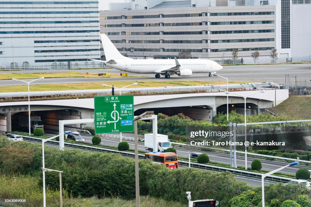 The airplane moving on Tokyo Haneda International Airport in Japan and Shuto Expressway Bayshore Route in Japan