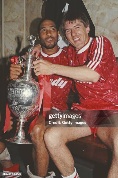 Liverpool players John Barnes and Peter Beardsley celebrate in the dressing room with the First Divison Trophy after winning the 1989/90 First...