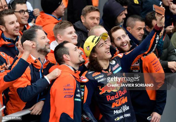 Race winner Red Bull KTM Ajo's Turkish rider Can Oncu takes a selfie photo as he celebrates with teammates winning the Moto3 race of the Valencia...