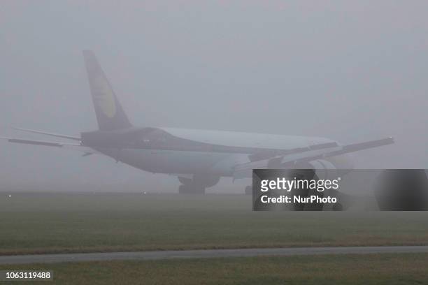 Jet Airways Boeing 777-300 in the mist at Amsterdam Schiphol International Airport. The aircraft registration is VT-JEQ and is a Boeing 777-300 ER or...