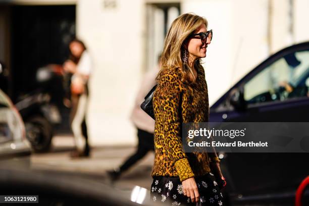 Guest wears a faux fur leopard print yellow coat, earrings and sunglasses, outside Chloe, during Paris Fashion Week Womenswear Spring/Summer 2019, on...