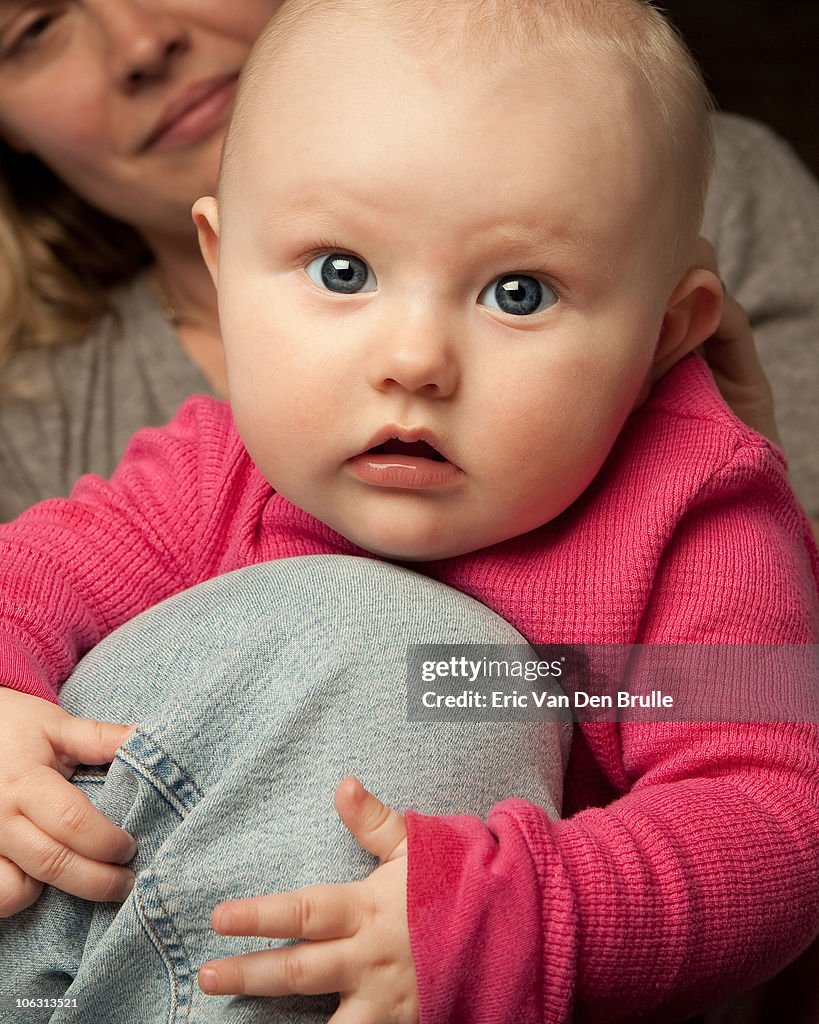 Baby girl on mothers knee