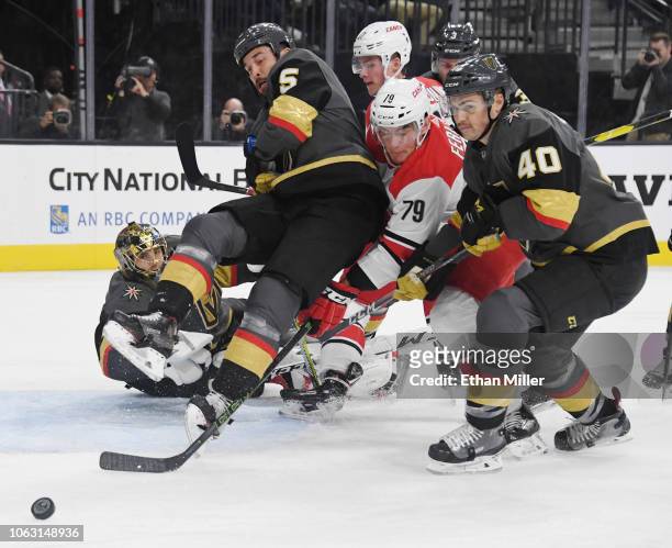 Marc-Andre Fleury, Deryk Engelland and Ryan Carpenter of the Vegas Golden Knights defend the net against a shot by Micheal Ferland of the Carolina...