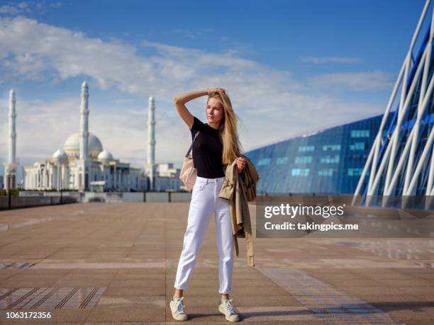 girl walking in center astana - white pants stock-fotos und bilder