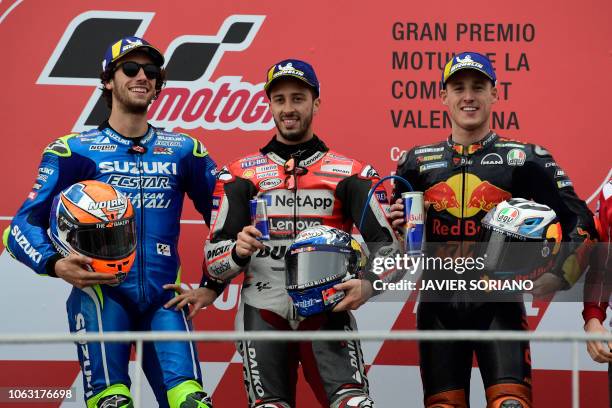 Race winner Ducati Team's Italian rider Andrea Dovizioso celebrates on the podium with second placed Team SUZUKI ECSTAR's Spanish rider Alex Rins and...