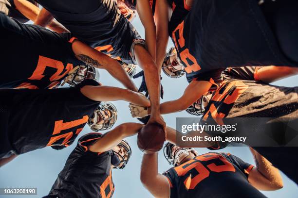 american football spelers huddling tijdens time-out - football team stockfoto's en -beelden