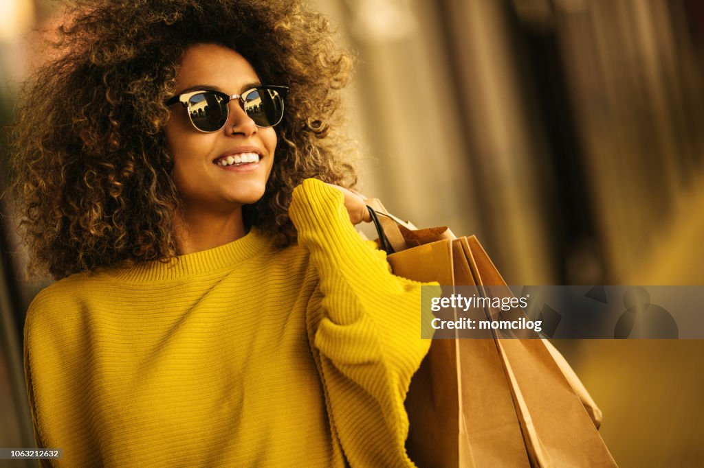 Schöne Mischungen Rennen Frau Einkaufstaschen hält lächelnd