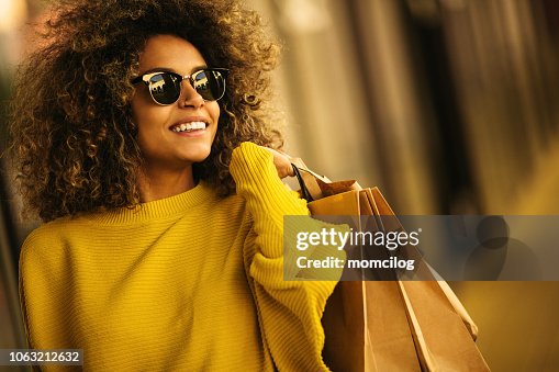 Beautiful mixes race woman holding shopping bags and smiling Beautiful mixes race woman holding shopping bags and smiling