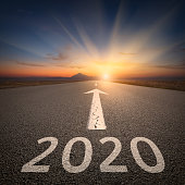 Driving to upcoming 2020 on open road at sunrise
