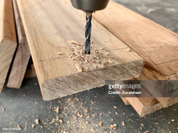 a close up of drill into wood in a workshop at kuala lumpur,  malaysia - drill stockfoto's en -beelden