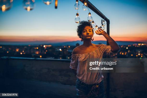jonge vrouw met string licht op dak - terraced field stockfoto's en -beelden
