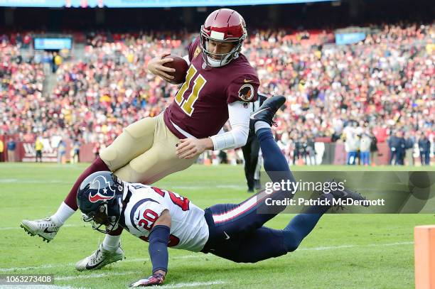 Alex Smith of the Washington Redskins is tackled by Justin Reid of the Houston Texans in the first half at FedExField on November 18, 2018 in...