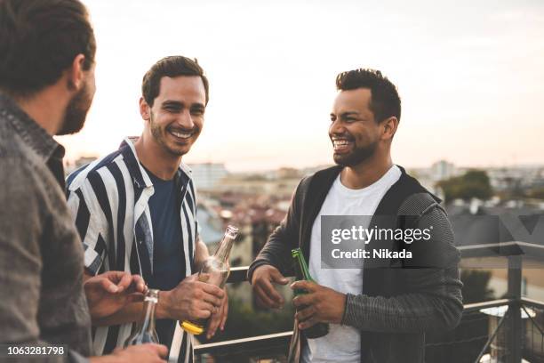 vrolijke vrienden genieten van op dak feestje - bier drinken stockfoto's en -beelden