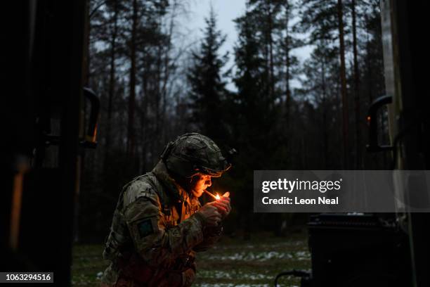 Major Paul Martin of B Company of the Royal Irish Regiment lights a cigar after setting up camp near a forest during the live exercise on November 2,...