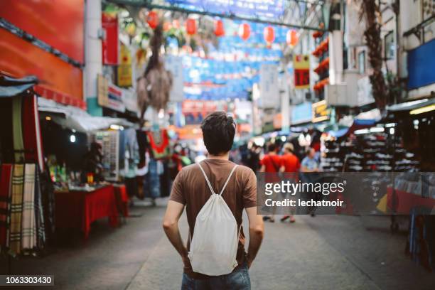 young solo traveler in kuala lumpur chinatown district - kuala lumpur stock pictures, royalty-free photos & images