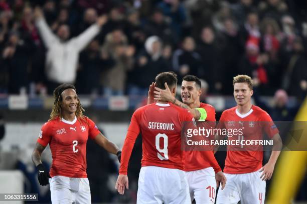 Switzerland's defender Kevin Mbabu, team mates forward Haris Seferovic, midfielder Granit Xhaka and defender Nico Elvedi reacts after Seferovic...