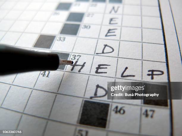 "help needed" writing on crossword puzzle - crosswords stock pictures, royalty-free photos & images