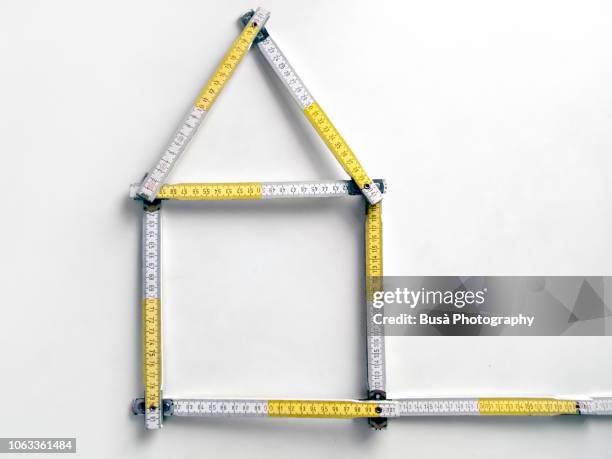 wooden white and yellow ruler in the shape of a house - werkzeug freisteller stock-fotos und bilder