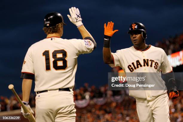 Edgar Renteria of the San Francisco Giants celebrates with Matt Cain after Renteria hits a fifth inning solo home run off of C.J. Wilson of the Texas...