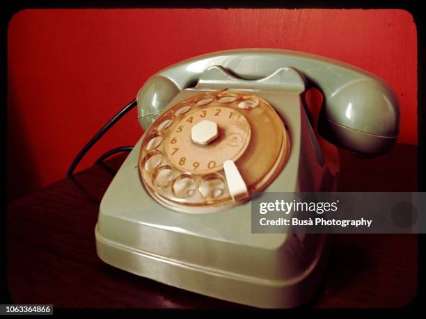 green vintage telephone against red wall - khaki green stock pictures, royalty-free photos & images