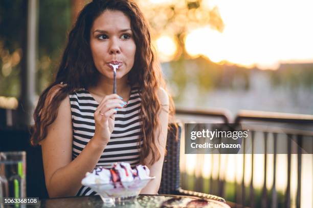 woman eating ice cream by the riverbank - mulher colher sorvete imagens e fotografias de stock