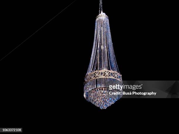 swinging chandelier in the night - chandelier stock pictures, royalty-free photos & images