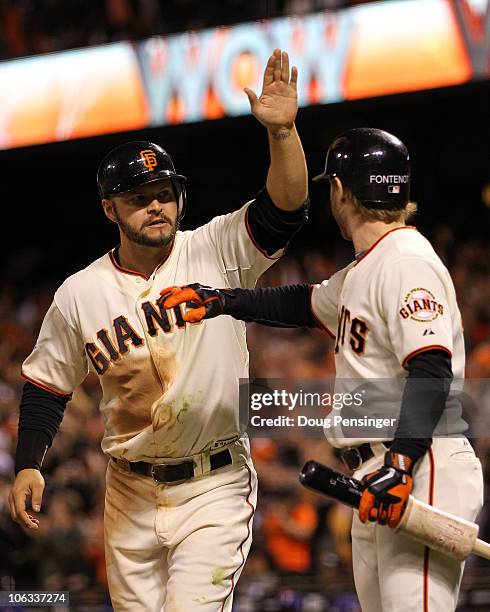 Cody Ross of the San Francisco Giants celebrates scoring a run with teammate Mike Fontenot in the eighth inning while taking on the Texas Rangers in...