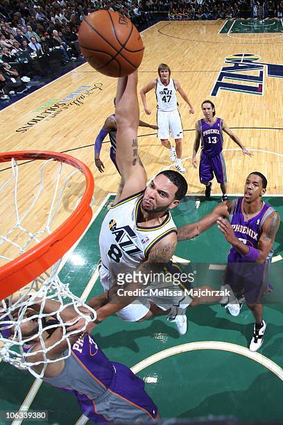 Deron Williams of the Utah Jazz goes for the dunk against the defense of the Phoenix Suns at EnergySolutions Arena on October 28, 2010 in Salt Lake...