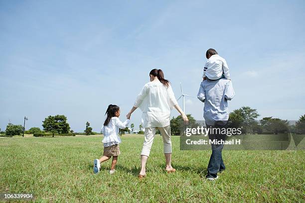 family who takes a turn in the park - park couple piggyback stock pictures, royalty-free photos & images