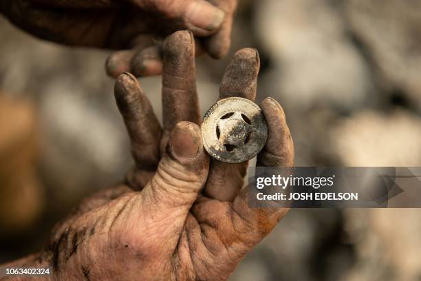 Ryan Spainhower displays a coin from his honeymoon that he found amidst the burned ashes of his home in Paradise, California on November 18, 2018.