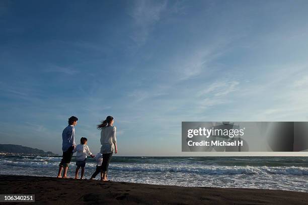 family who sees sea in beach in evening - japanese couple beach stock pictures, royalty-free photos & images