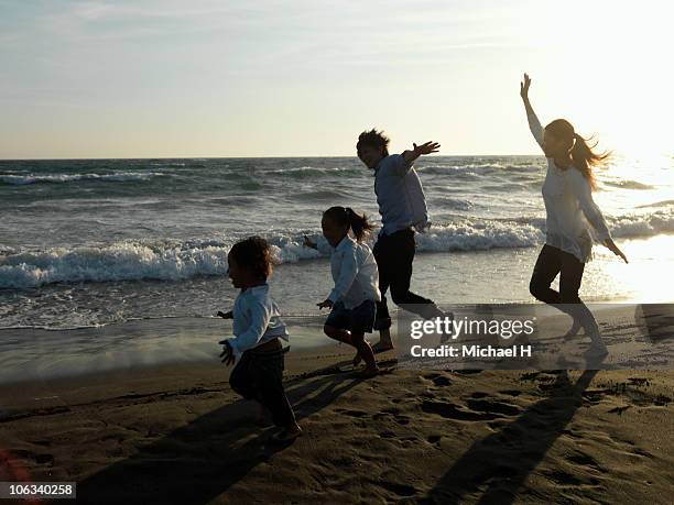 family who mimics airplane in beach and runs - 家族　日本人　走る ストックフォトと画像