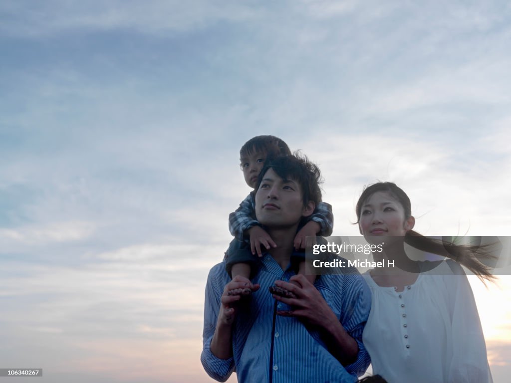 Portrait of family who stands in beach in evening