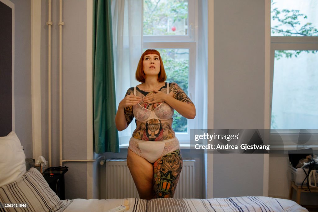 Tattooed woman putting on lotion
