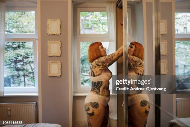tattooed woman getting dressed - seminua imagens e fotografias de stock