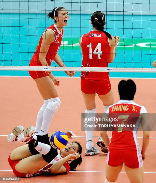 Naz Aydemir of Turkey reacts when her teammate Eda Erdem blocks a spike from Li Juan of China while China's Zhang Xian looks on during their first...